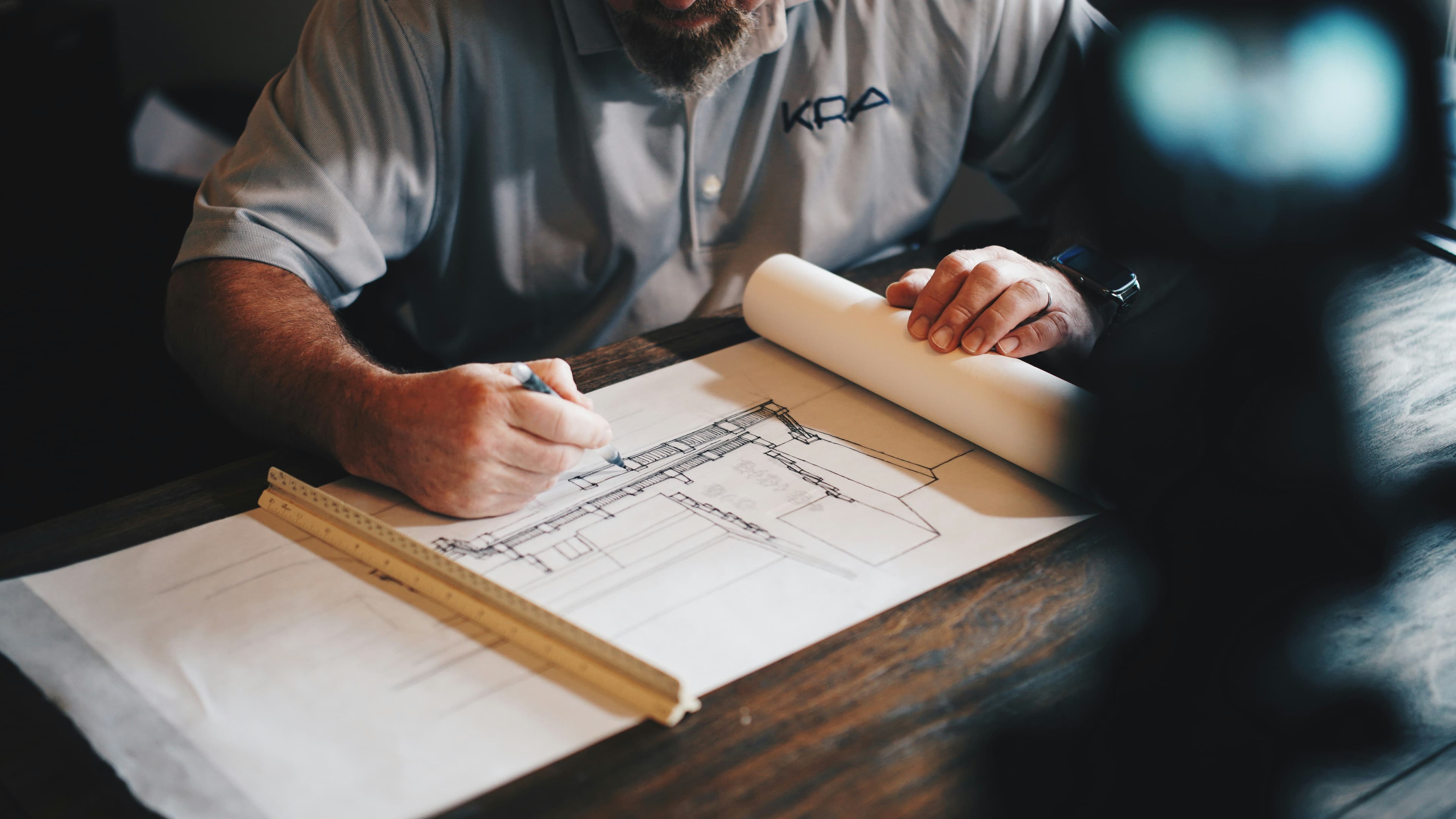 Architect working on a technical drawing with a pencil and ruler